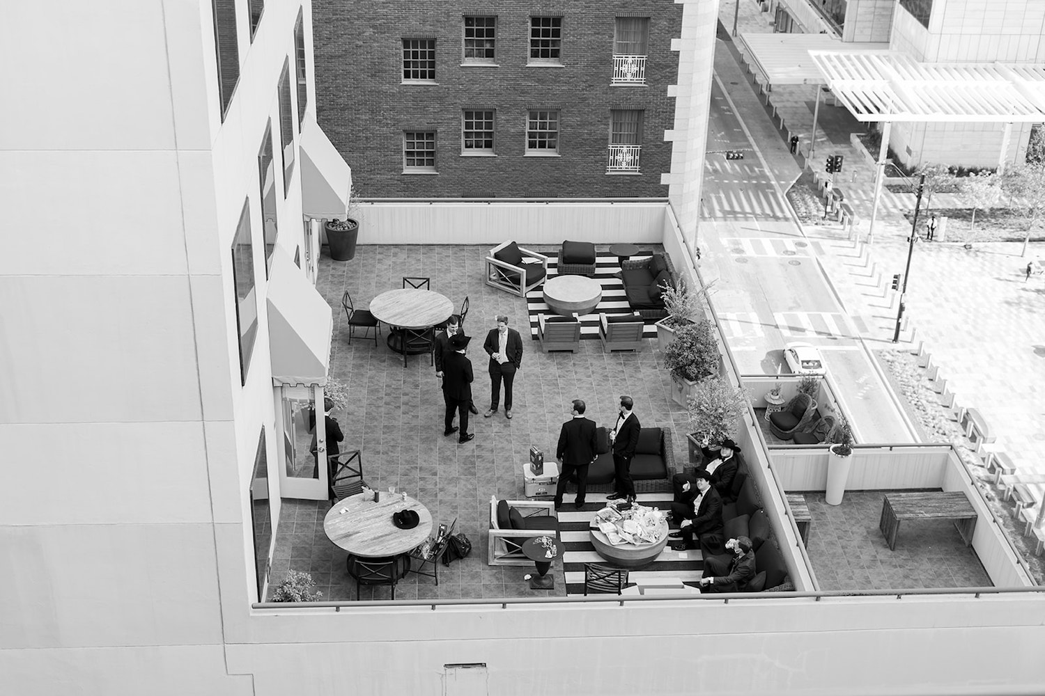 Black and white photo of the rooftop of The Adolphus Hotel in Dallas where the groomsmen are hanging out before the wedding ceremony