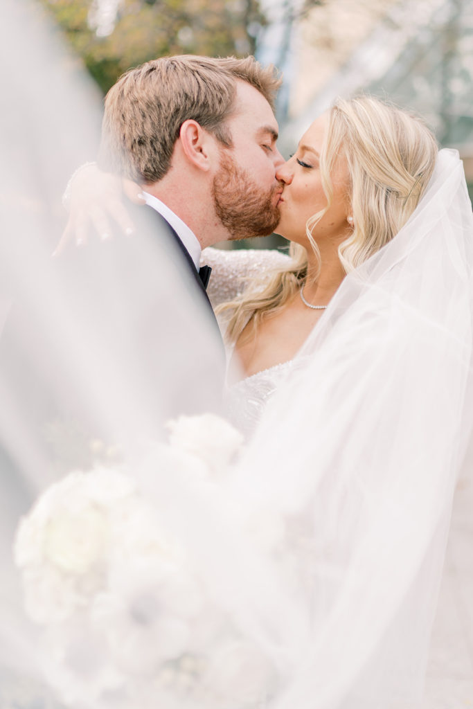 Bride and groom share a kiss during their wedding at The Adolphus Hotel in Dallas, Texas