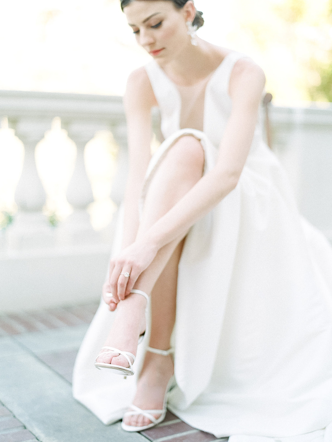Bride fixing her bridal shoe on terrace of the Arlington Hall Special Events, shot by Mackenzie Reiter 