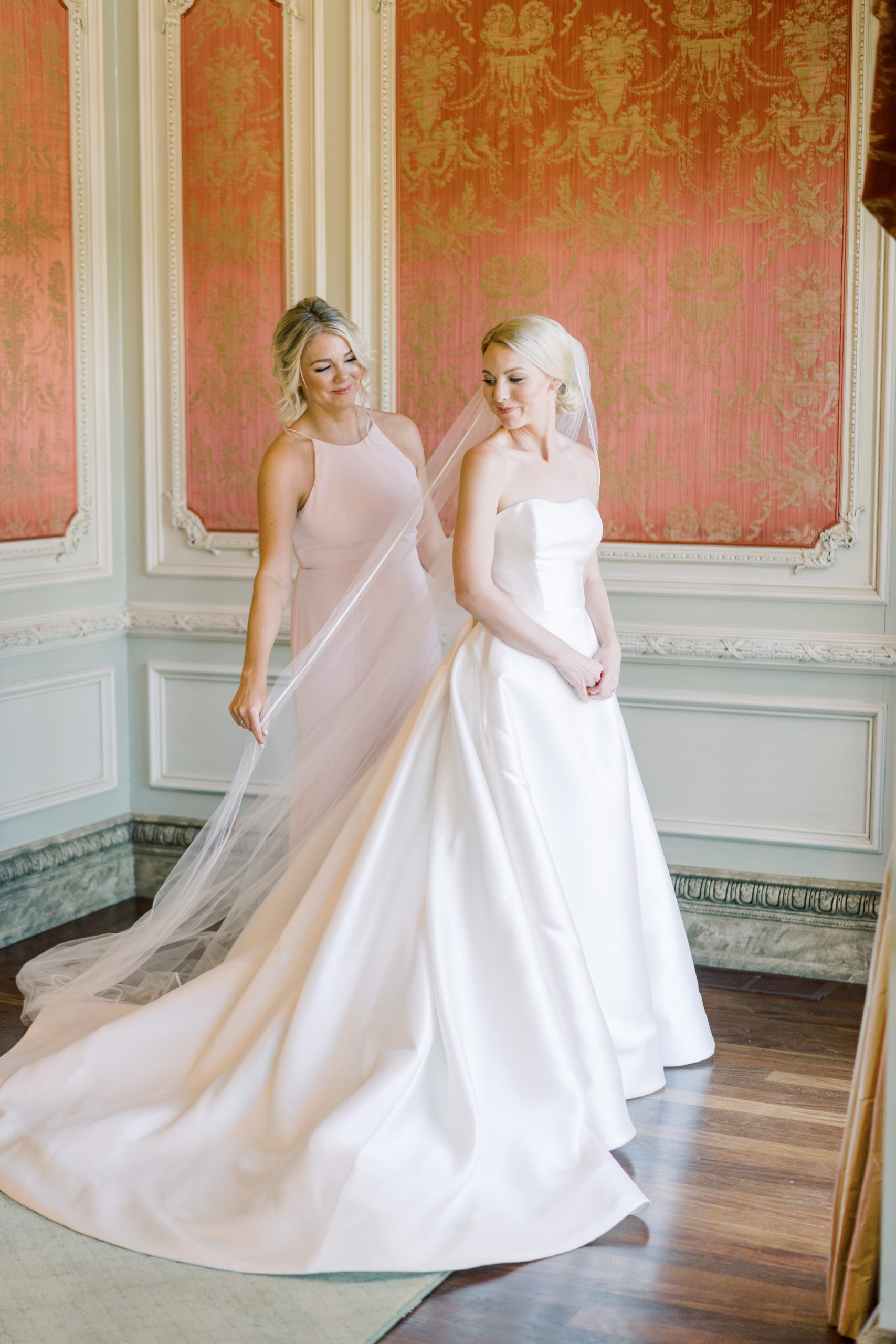 Bride poses with her maid of honor in one of the suites at The Olana