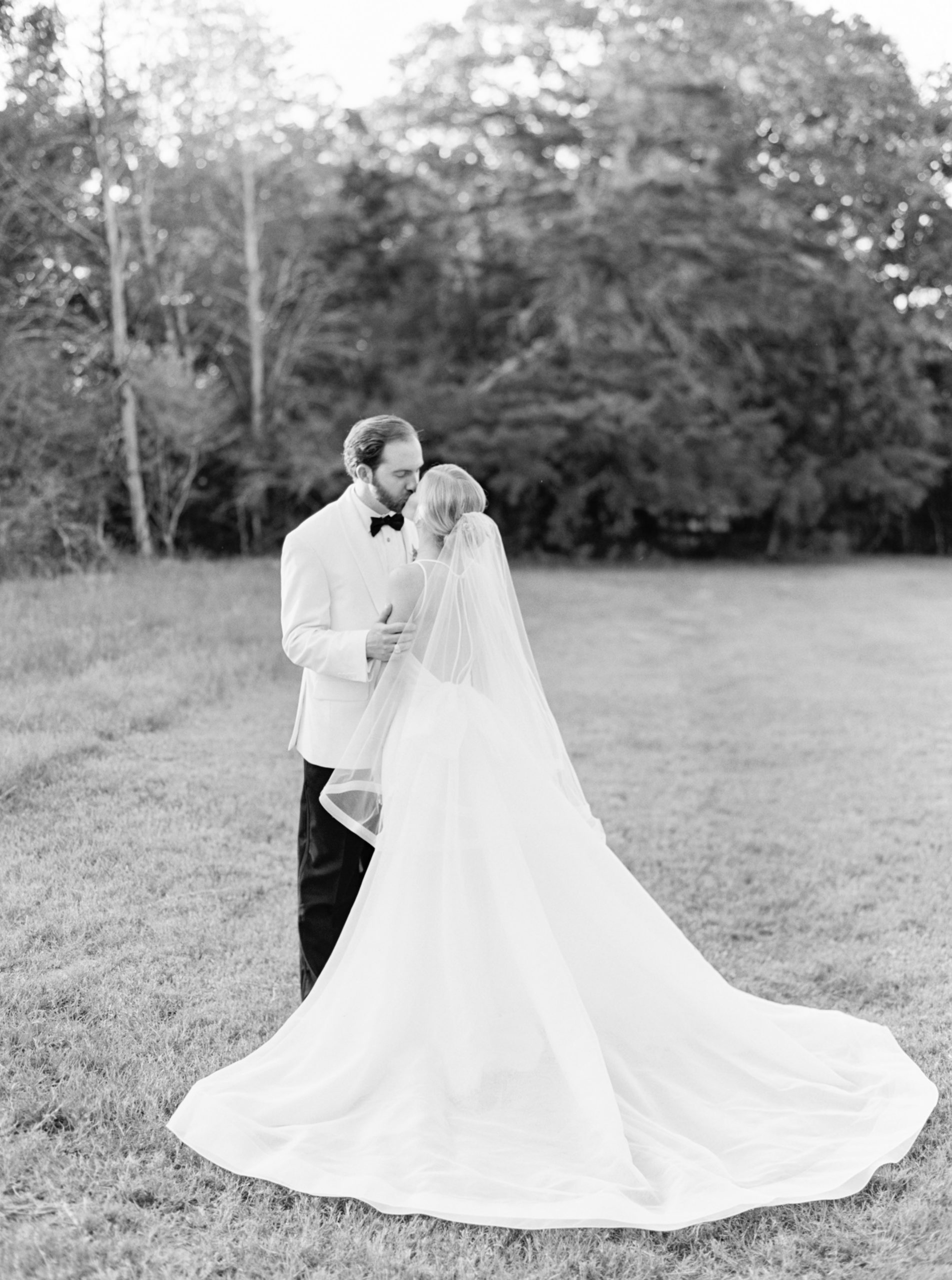 Black and white photo of the bride and groom kissing in the middle of Rosewood Mansion on Turtle Creek