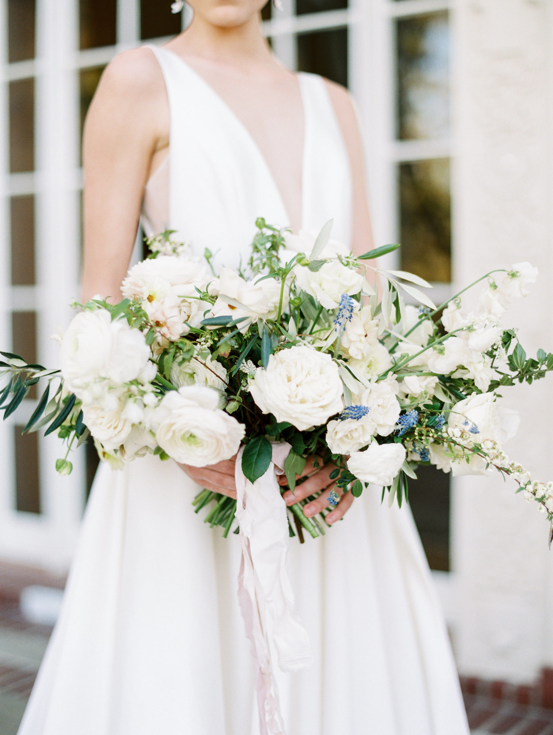 Close-up shot of the bride holding on to her gorgeous white rose bouquet